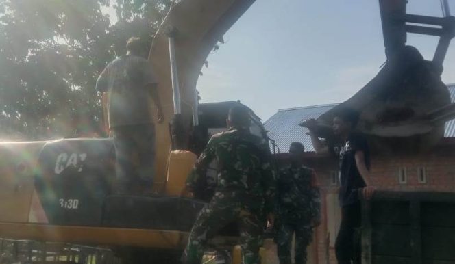 
 Anggota Satgas TMMD Serda Hamdan Bantu Operator Alat Berat Mengisi Bahan Bakar