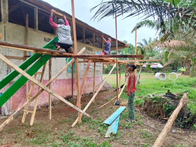 
 Dengan Cekatan, Anggota Satgas TMMD dan Warga Pasang Lisplang Madrasah