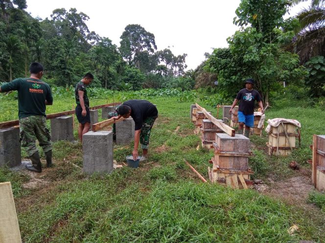 
 Warga dan Satgas TMMD Bahu-membahu Memasang Gelagar Lantai Kandang Kambing