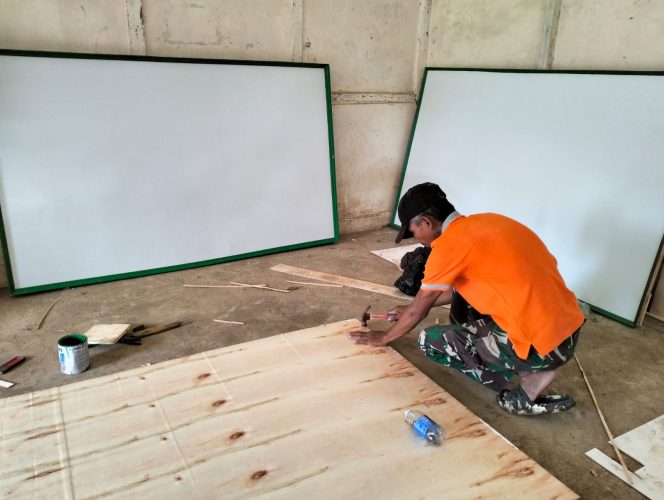 
 Menunjang Kegiatan Belajar, Anggota Satgas Membuat Papan Tulis