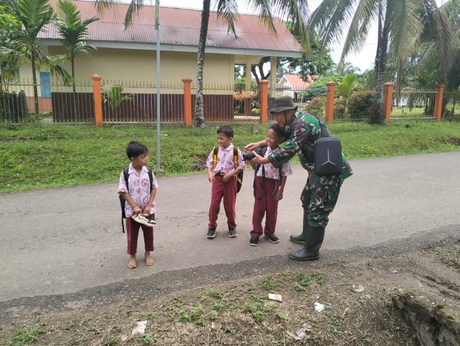 
 Anggota Tim Pendim 0416/Bute Mengajarkan Cara Menggunakan Kamera pada Anak-anak di Lokasi TMMD
