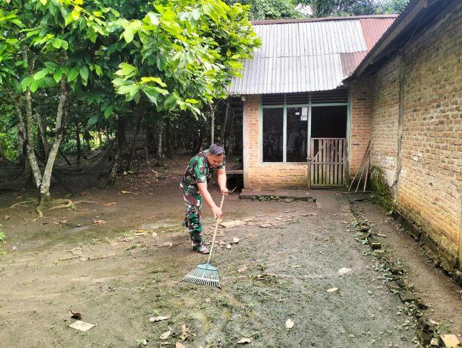 
 Anggota Satgas TMMD Praka Sukron Membersihkan Perkarangan Rumah Orang Tua Asuh