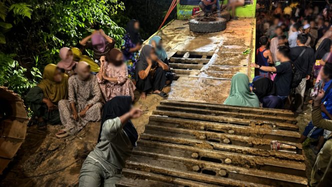 
 Warga yang menghadang jajaran kepolisian saat evakuasi alat berat excavator ke mobil Trado