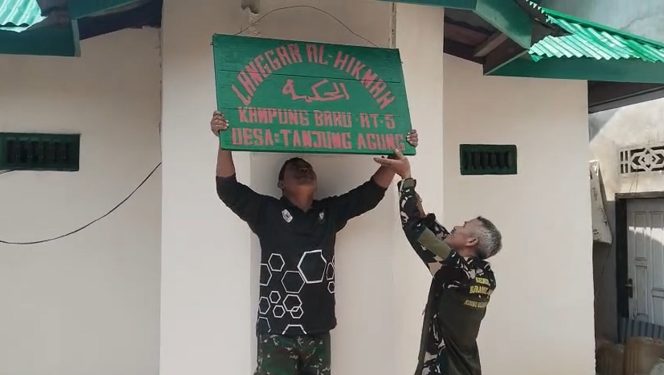 
 Anggota TNI Memasang Papan Merek Langgar Al-Hikmah di Dusun Tanjung Agung